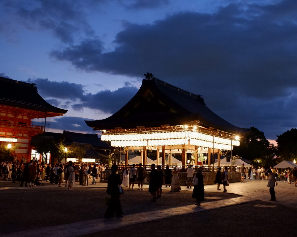 10月の観月祭のときの舞殿の写真。暗い空暗い地面に明るく灯された舞殿が際立っている。