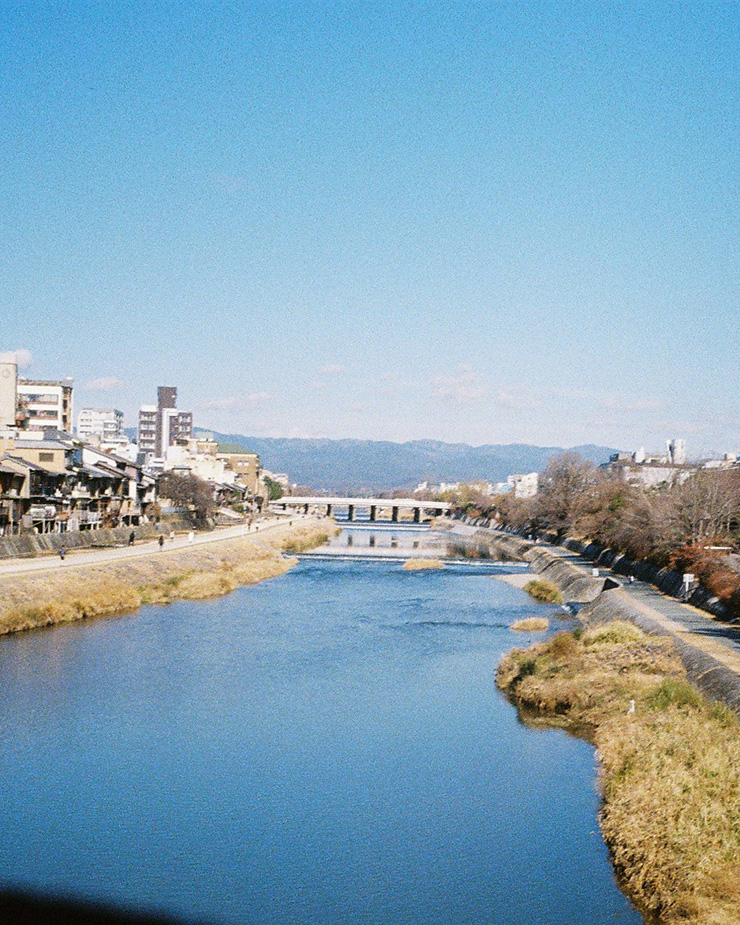 青く写った川と空、奥には別の橋が見える。